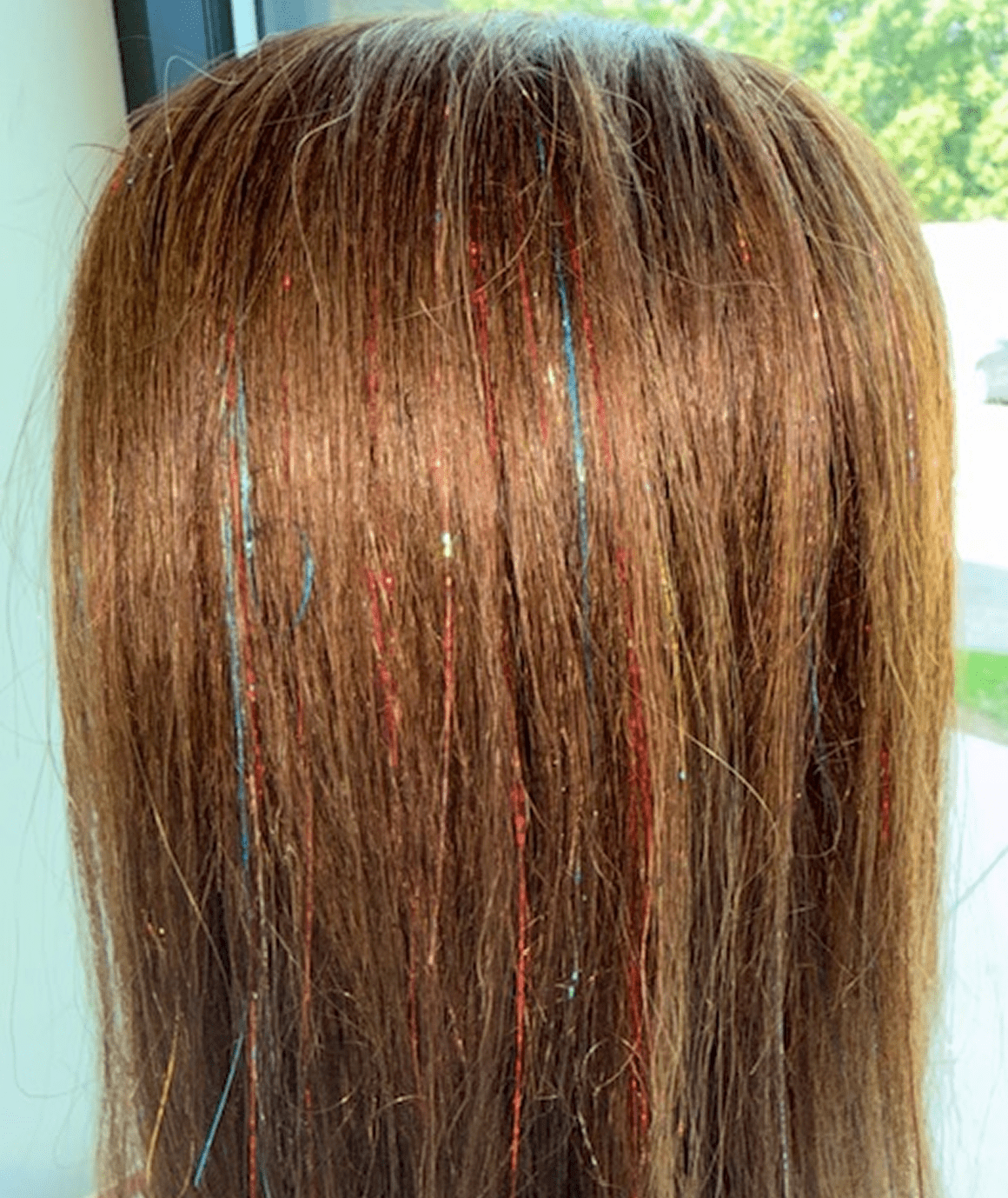 Brown hair with colorful tinsel strands.