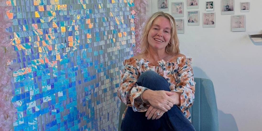 Woman sitting in colorful, decorated room.
